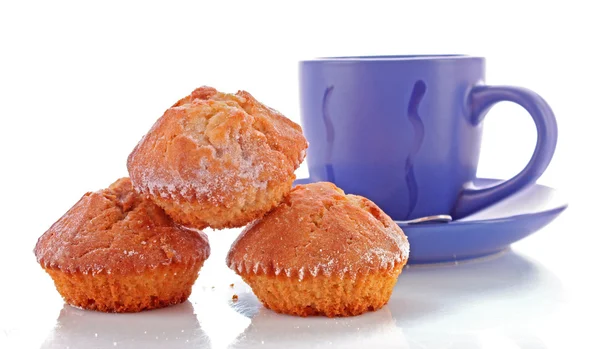 Drei Cupcakes und blaue Tasse auf weißem Hintergrund — Stockfoto