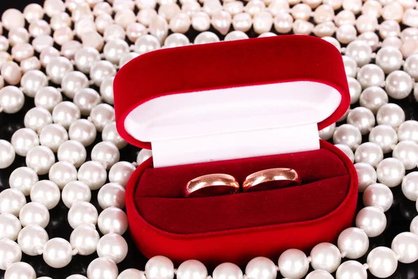 Anéis de casamento em uma caixa e pérolas — Fotografia de Stock