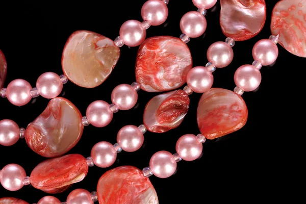 Χάντρες από ροζ μαργαριτάρια σε μαύρο φόντο — Φωτογραφία Αρχείου