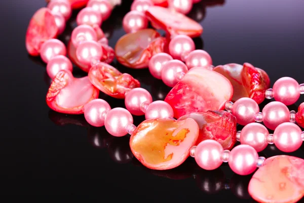 Korálky z růžových perel na černém pozadí — Stock fotografie