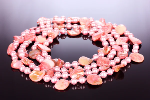 Collar de perlas rosadas y conchas marinas sobre un fondo gris —  Fotos de Stock