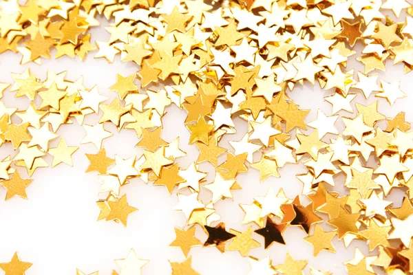 Золотые звезды в виде конфетти на белом — стоковое фото