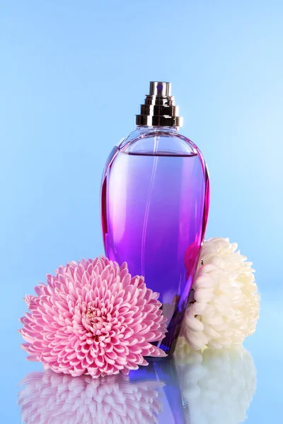 Parfymflaska på blå bakgrund — Stockfoto