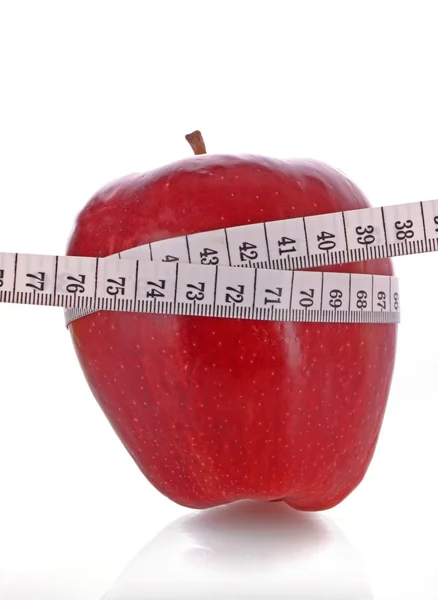 Witte meetlint rond een rode appel vertegenwoordigen dieet — Stockfoto