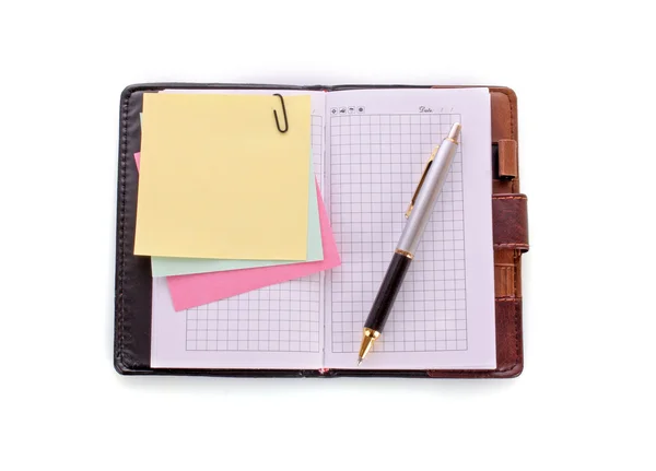 Cuaderno abierto con bolígrafo sobre blanco — Foto de Stock