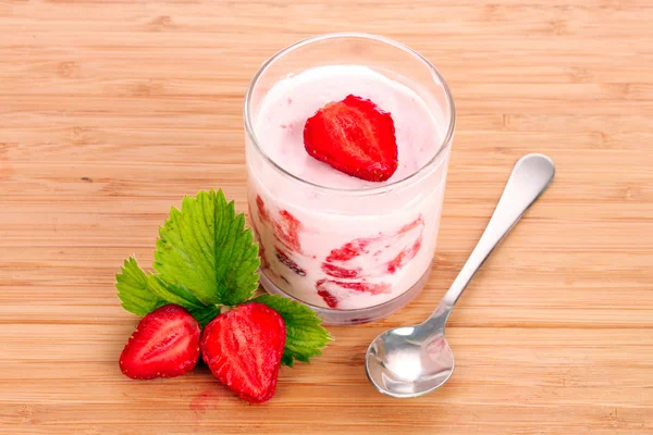 Yoghurt en aardbei op een houten achtergrond — Stockfoto