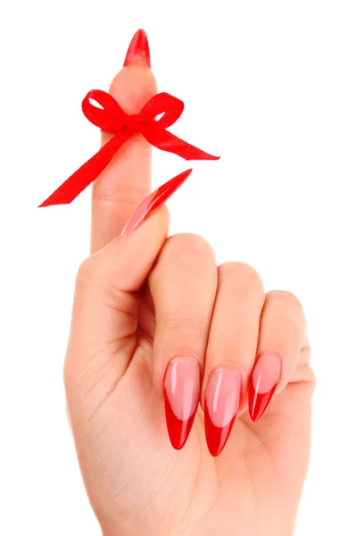 Nagels met rode nagellak en een boog op de vinger — Stockfoto