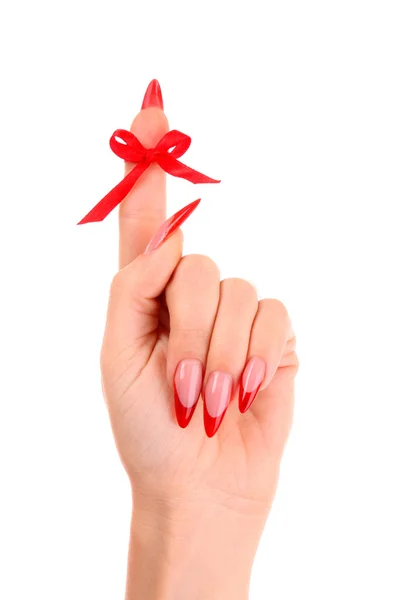 Pregos com esmalte vermelho e um arco no dedo — Fotografia de Stock
