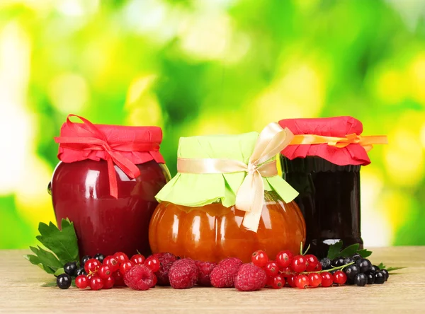 Baya sabrosa y mermelada de frutas y bayas sobre un fondo verde —  Fotos de Stock