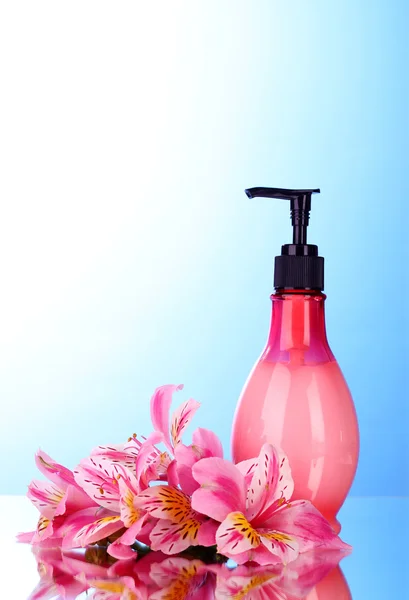 Cosmetic cream and lily on blue background — Stock Photo, Image
