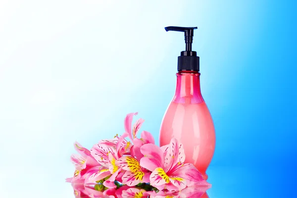 Kosmetikcreme und Lilie auf blauem Hintergrund — Stockfoto