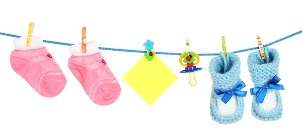 Baby sokken en slofjes aan een touw geïsoleerd op wit — Stockfoto