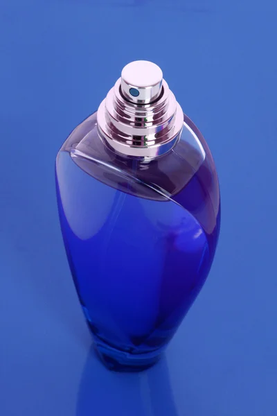 Bottiglia di profumo su sfondo viola — Foto Stock