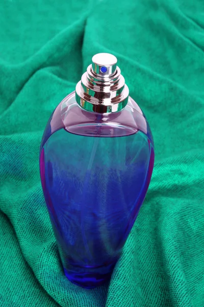 Frasco de perfume sobre fondo azul — Foto de Stock