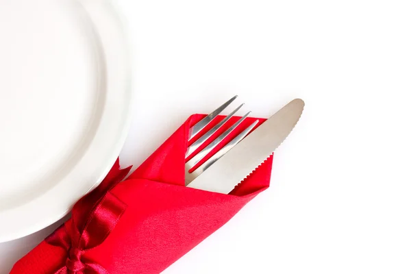 Faca e garfo em um pano vermelho, isolado em branco — Fotografia de Stock