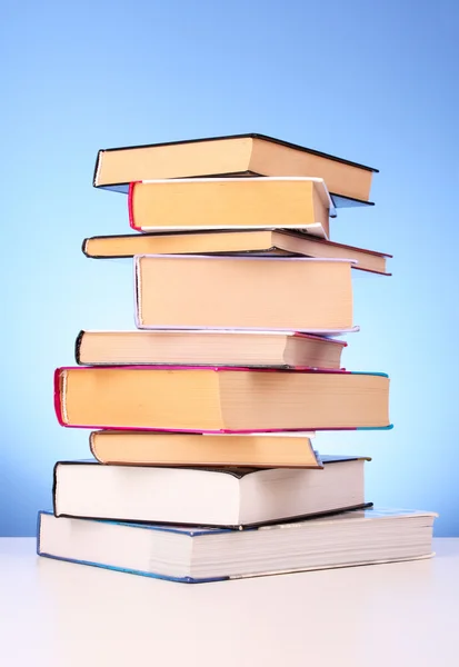 Böcker högen på bordet och gul bakgrund — Stockfoto