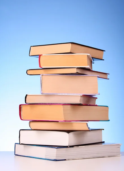 Bücher stapeln sich auf dem Tisch und gelber Hintergrund — Stockfoto