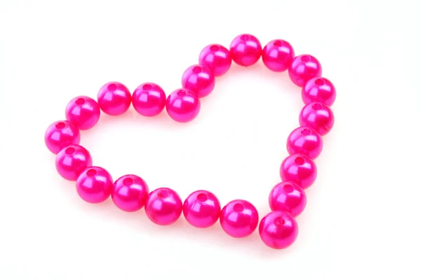 Herz aus rosa Perlen isoliert auf weißem Hintergrund — Stockfoto