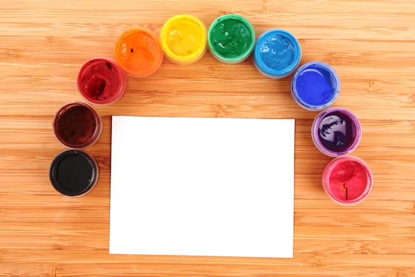 Opened paint buckets colors and paper on the table — Stock Photo, Image
