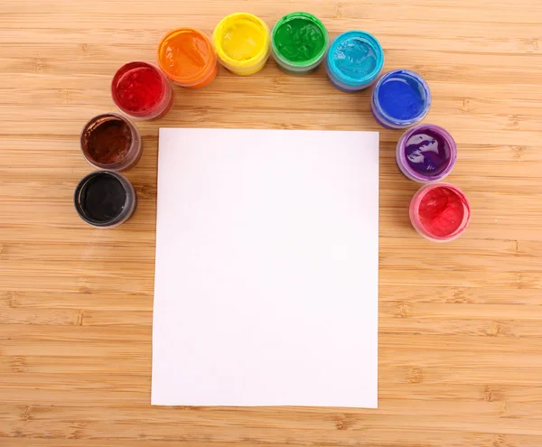 Geöffnete Farbeimer Farben und Papier auf dem Tisch — Stockfoto