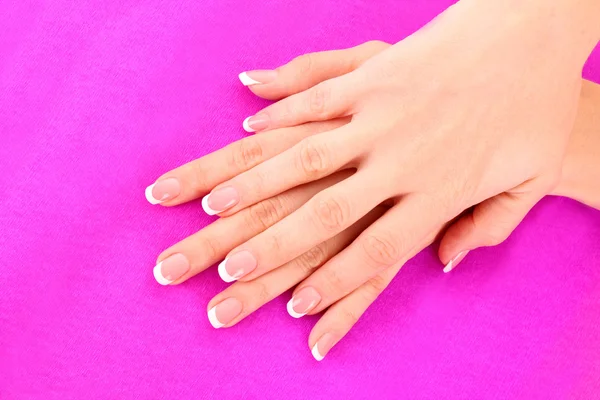 Beautiful woman hand with french manicure on pink background — Stock Photo, Image