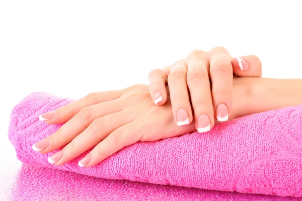 Schöne Frau Hand mit französischer Maniküre auf rosa Hintergrund — Stockfoto