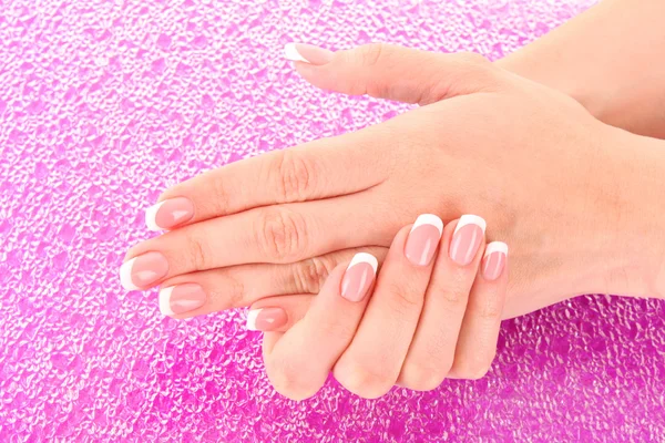 Beautiful woman hands with french manicure on pink background — Stock Photo, Image