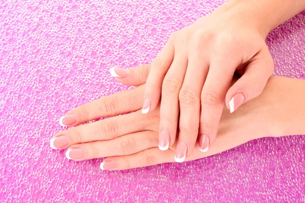 Piękna kobieta ręce z Francuski manicure na różowym tle — Zdjęcie stockowe