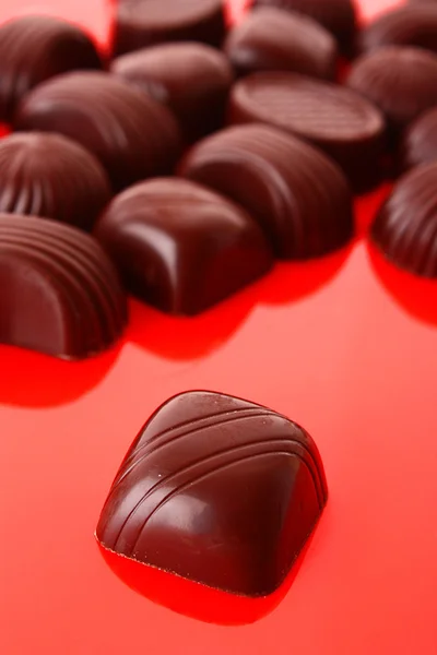 Assorted chocolate candies on red background — Stock Photo, Image