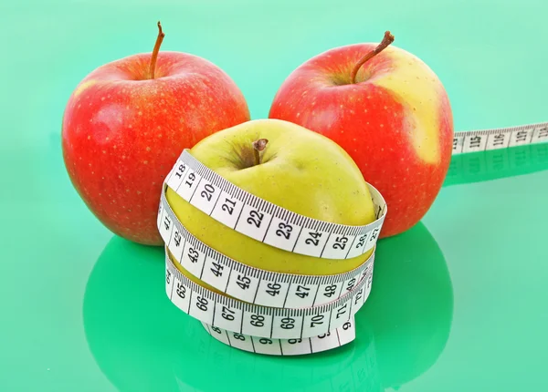 Fita métrica branca em torno de uma maçã vermelha que representa a dieta — Fotografia de Stock