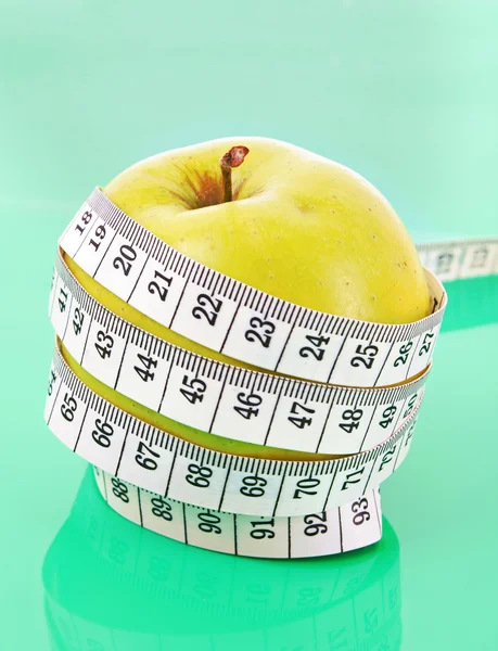 Weißes Band messen um einen grünen Apfel, der Diät repräsentiert — Stockfoto