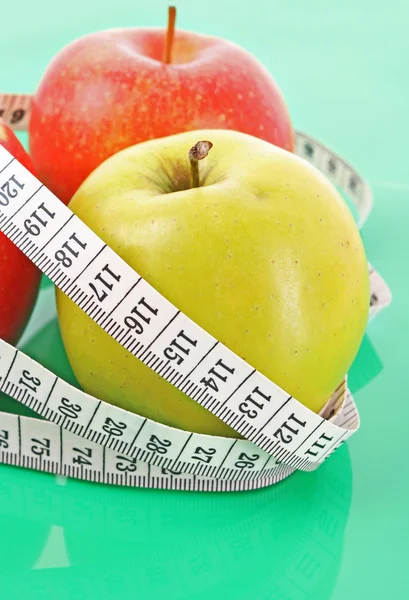 Misura nastro bianco intorno a una mela rossa che rappresenta la dieta — Foto Stock