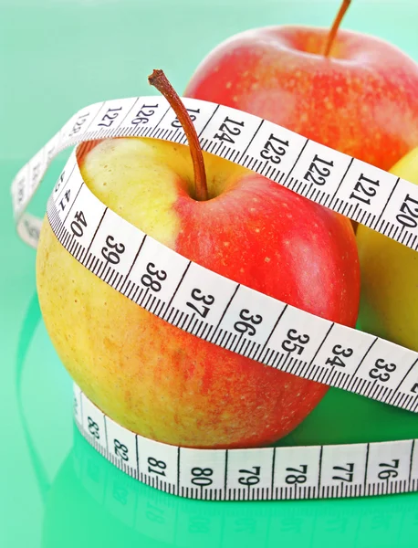 White tape measure around a red apple representing dieting — Stock Photo, Image
