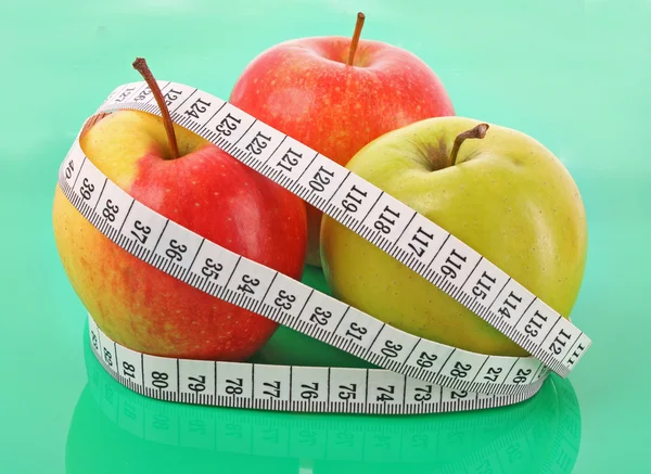 Fita métrica branca em torno de uma maçã vermelha que representa a dieta — Fotografia de Stock