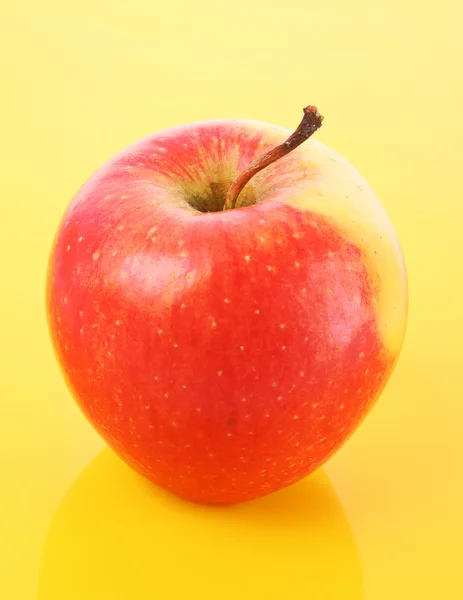 Сочное красное яблоко на желтом — стоковое фото