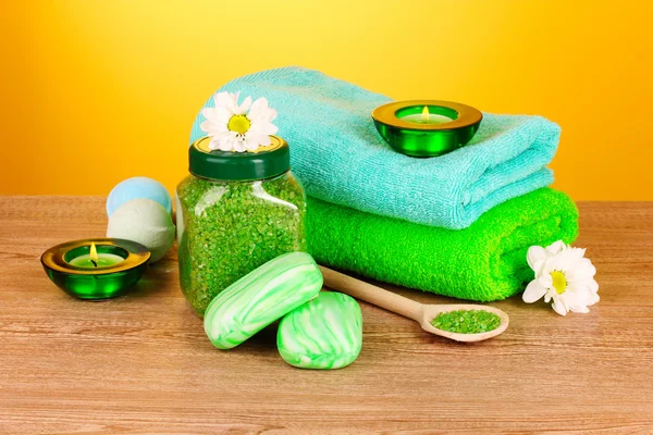 Badesalz, Seife und Handtuch auf gelbem Hintergrund — Stockfoto