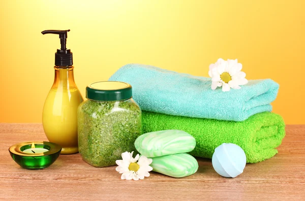 Badsalt, tvål och handduk på gul bakgrund — Stockfoto
