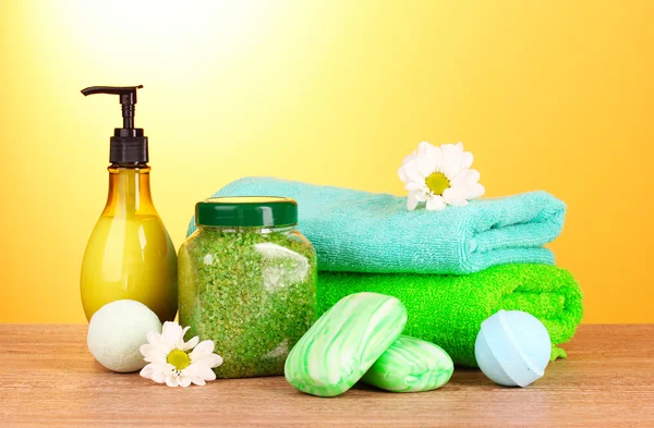 Bagno di sale, sapone e asciugamano su sfondo giallo — Foto Stock
