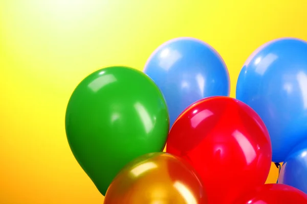 Sarı bir arka plan üzerinde uçan balonlar — Stok fotoğraf