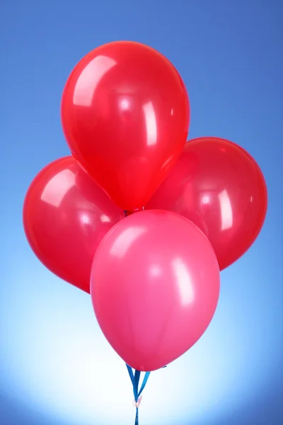 Rózsaszín repülő léggömbök, kék háttérrel — Stock Fotó