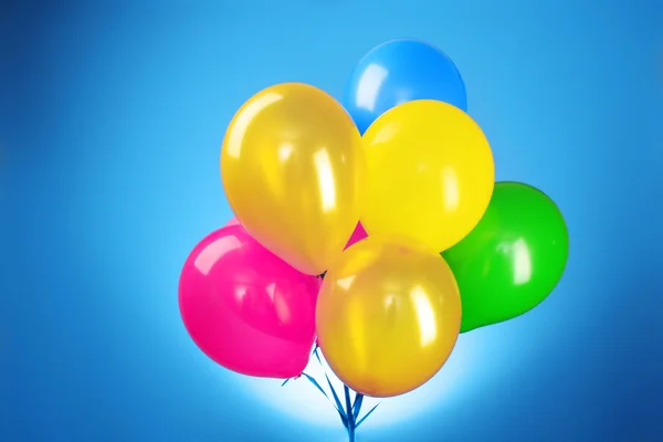 Růžová létající balóny na modrém pozadí — Stock fotografie
