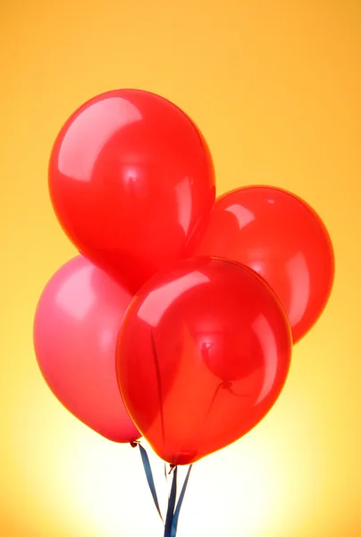 Rosa flygande ballonger på gul bakgrund — Stockfoto