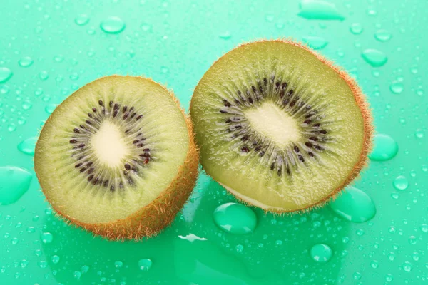 Wet kiwi on green background — Stock Photo, Image
