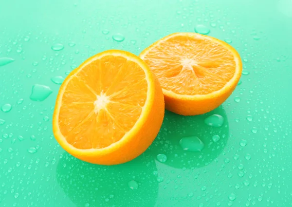 Pomarańcza mokra na zielonym tle — Zdjęcie stockowe