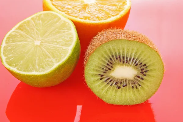 Orange och andra frukter på röd — Stockfoto