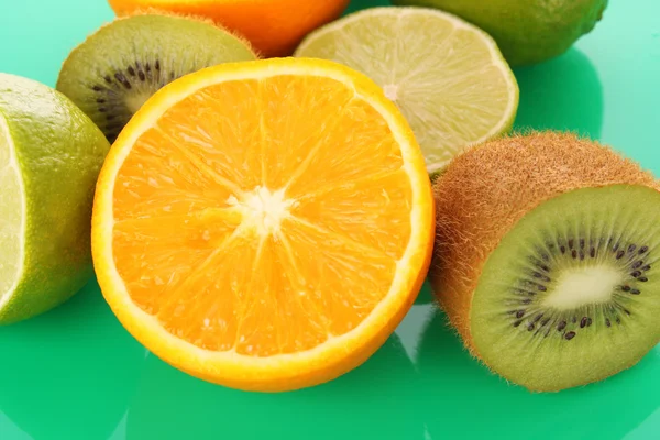Orange and other fruits on green — Stock Photo, Image