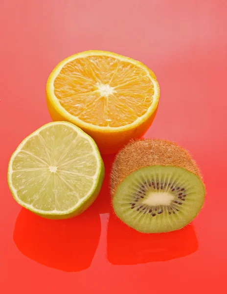 Orange och andra frukter på röd — Stockfoto
