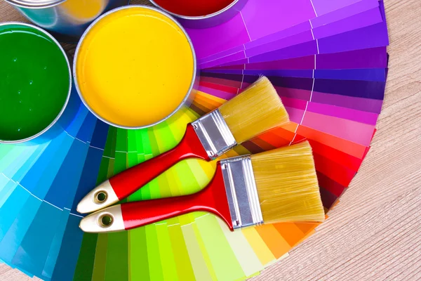 Open tin cans with paint and palette — Stock Photo, Image