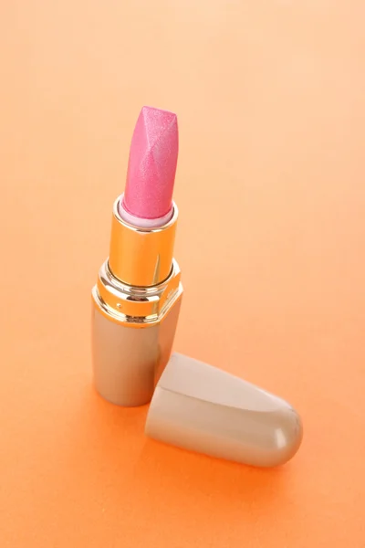 Neuer Lippenstift auf orangefarbenem Hintergrund — Stockfoto