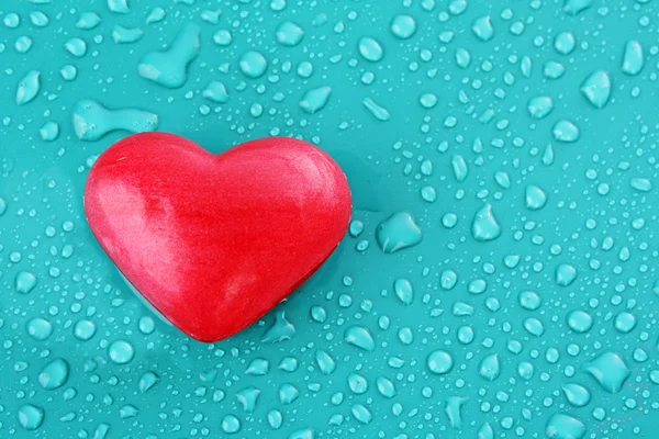 Mýdlo ve tvaru srdce na modré vody kapky pozadí — Stock fotografie